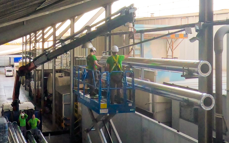 Instalación industrial con tuberías y sistemas de climatización eficiente bajo el texto Certificados de Ahorro Energético CAE.